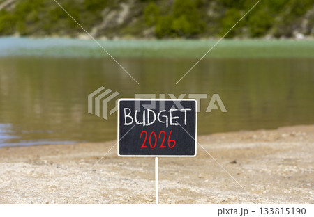 Budget 2026 symbol. Concept words Budget 2026 on beautiful black blackboard. Beautiful mountain lake sand beach background. Business and budget 2026 concept. Copy space. Budget 2026 symbol. Concept words Budget 2026 on beautiful black blackboard. Beautiful mountain lake sand beach background. Business and budget 2026 concept. Copy space. 133815190