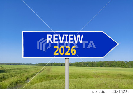 Review 2026 symbol. Concept words Review 2026 on beautiful blue road sign. Beautiful green grass field forest and blue sky background. Business and review 2026 concept. Copy space. Review 2026 symbol. Concept words Review 2026 on beautiful blue road sign. Beautiful green grass field forest and blue sky background. Business and review 2026 concept. Copy space. 133815222