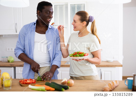 Happy biracial family couple cooking healthy vegetable dinner together Happy biracial family couple cooking healthy vegetable dinner together 133815289