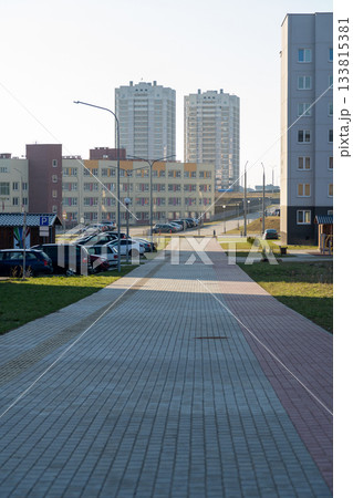 A modern urban residential area featuring apartment complexes and a paved walkway A modern urban residential area featuring apartment complexes and a paved walkway 133815381