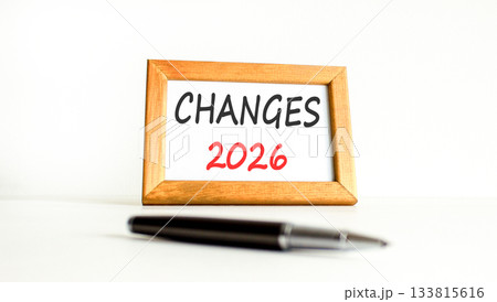 Changes 2026 symbol. Concept words Changes 2026 on beautiful wooden picture frame. Beautiful white paper background. Beautiful black pen. Business and changes 2026 concept. Copy space. 133815616