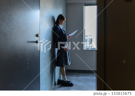 廊下で書類を読む女子学生 133815675
