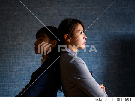 対立する2人のビジネスウーマン、背中合わせの緊張感 133815691