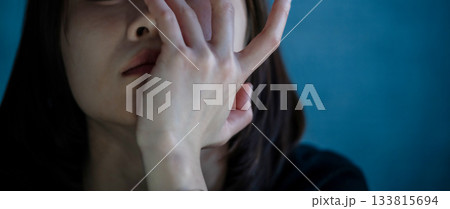 暗い青の背景で顔を覆う女性の手 133815694