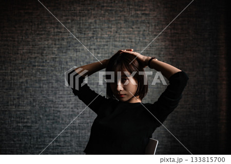 暗い部屋でポーズをとる若い女性 暗い部屋でポーズをとる若い女性 133815700