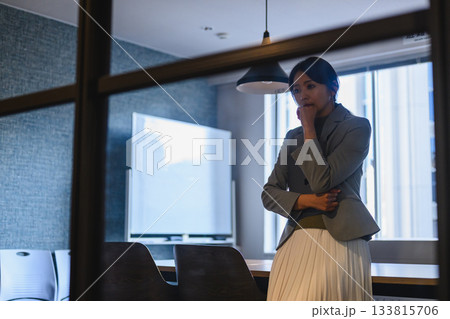 会議室で考え込むスーツ姿の日本人女性ビジネスパーソン 会議室で考え込むスーツ姿の日本人女性ビジネスパーソン 133815706