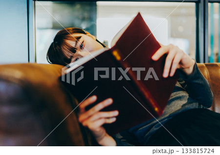 革張りのソファで本を読む若い女性 133815724