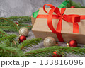 Christmas composition. Gift box, fir tree branches, red and gold decorations on grey background. High quality photo 133816096