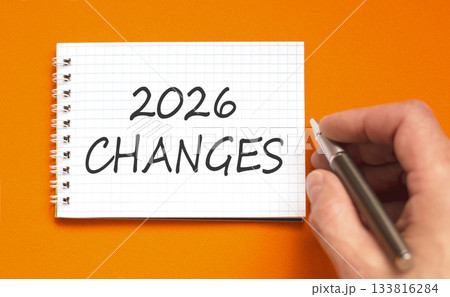 2026 Changes symbol. Concept words 2026 Changes on beautiful white note. Beautiful orange paper background. Businessman's hand with pen. Business and 2026 changes concept. Copy space. 2026 Changes symbol. Concept words 2026 Changes on beautiful white note. Beautiful orange paper background. Businessman's hand with pen. Business and 2026 changes concept. Copy space. 133816284