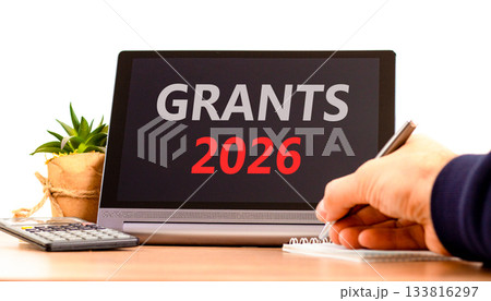Grants 2026 symbol. Concept words Grants 2026 on beautiful black tablet screen. Beautiful white background. Businessman's hand. Business and grants 2026 concept. Copy space. 133816297