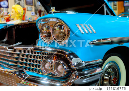 Classic blue vintage car showcased in retro garage with unique decorations nostalgic items Classic blue vintage car showcased in retro garage with unique decorations nostalgic items 133816776