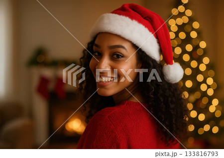 Smiling Young Woman in Santa Hat Enjoying Cozy Christmas Evening at Home Smiling Young Woman in Santa Hat Enjoying Cozy Christmas Evening at Home 133816793