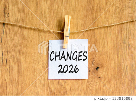 Changes 2026 symbol. Concept words Changes 2026 on beautiful white paper on wooden clothespin. Beautiful wooden background. Business and changes 2026 concept. Copy space. 133816898
