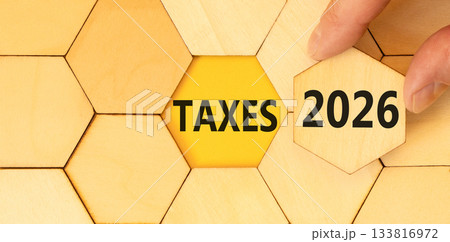 Taxes 2026 new year symbol. Concept words Taxes 2026 on beautiful wooden puzzles. Beautiful wooden puzzles background. Businessman's hand. Business and taxes 2026 new year concept. Copy space. Taxes 2026 new year symbol. Concept words Taxes 2026 on beautiful wooden puzzles. Beautiful wooden puzzles background. Businessman's hand. Business and taxes 2026 new year concept. Copy space. 133816972