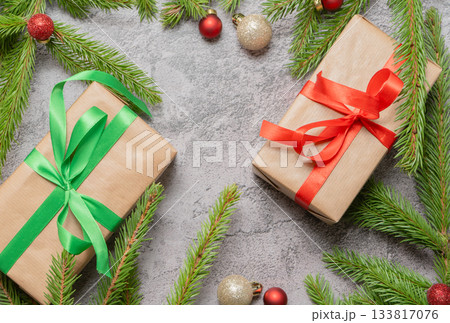 Christmas composition. Gift boxes, fir tree branches, red and gold decorations on grey background. High quality photo 133817076