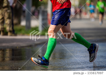 Runner legs in green compression sleeves 133817097