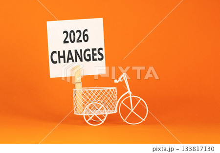 2026 Changes symbol. Concept words 2026 Changes on beautiful white paper on wooden clothespin. Beautiful orange background. Beautiful miniature bicycle. Business and 2026 changes concept. Copy space. 133817130