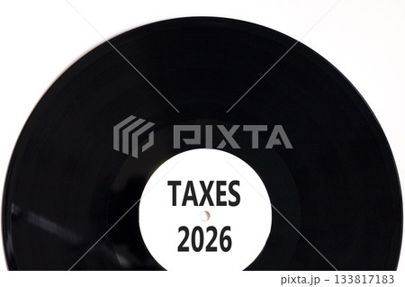 Taxes 2026 new year symbol. Concept words Taxes 2026 on beautiful white and black vinyl disk. Beautiful white paper background. Business and taxes 2026 new year concept. Copy space. Taxes 2026 new year symbol. Concept words Taxes 2026 on beautiful white and black vinyl disk. Beautiful white paper background. Business and taxes 2026 new year concept. Copy space. 133817183