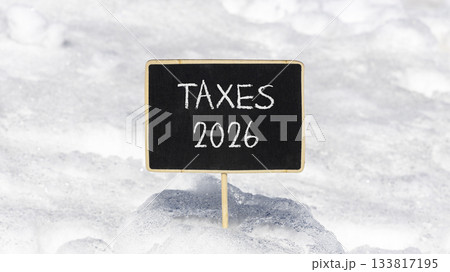 Taxes 2026 new year symbol. Concept words Taxes 2026 on beautiful black blackboard. Beautiful white snow background. Business and taxes 2026 new year concept. Copy space. Taxes 2026 new year symbol. Concept words Taxes 2026 on beautiful black blackboard. Beautiful white snow background. Business and taxes 2026 new year concept. Copy space. 133817195