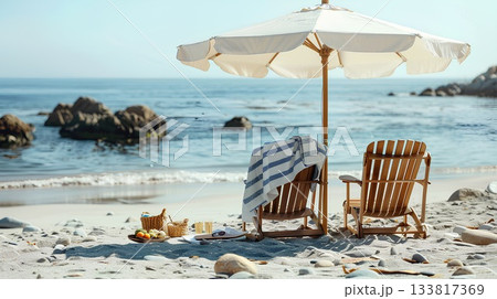 beach scene with two wooden chairs under an umbrella, each chair wrapped in a white and blue striped towel, and some snacks on the sand beside them. 133817369
