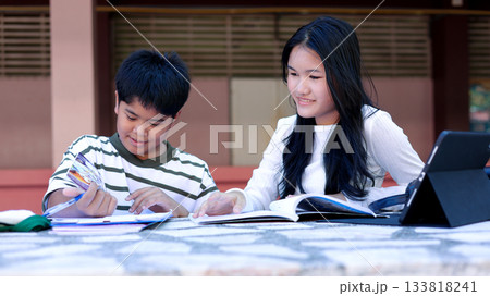 Asian Students Studying Together Outdoors with Books and Tablet 133818241