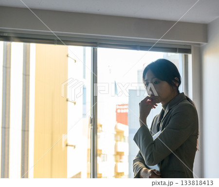 窓辺で物思いにふける20代ビジネスウーマンのポートレート 窓辺で物思いにふける20代ビジネスウーマンのポートレート 133818413