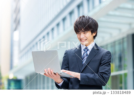 オフィスでノートパソコンを持つビジネスマン オフィスでノートパソコンを持つビジネスマン 133818489
