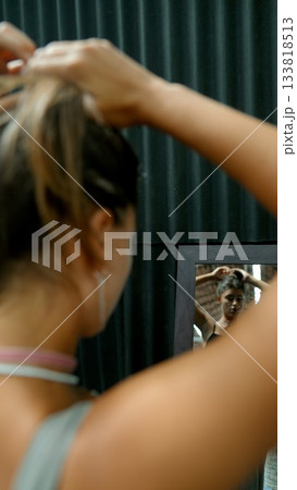 A Woman Preparing for an Important Special Occasion While Looking at Her Reflection in a Mirror A Woman Preparing for an Important Special Occasion While Looking at Her Reflection in a Mirror 133818513