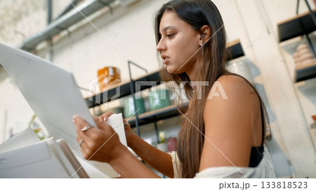 A Creative Woman Dedicatedly Engaging in Her Work With Various Art and Design Documents A Creative Woman Dedicatedly Engaging in Her Work With Various Art and Design Documents 133818523