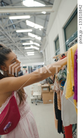 A Fashion Shopper Happily Exploring a Colorful Clothing Rack Inside a Modern Boutique 133818842