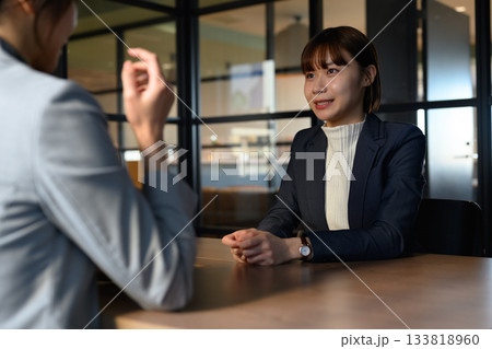 オフィスでの面接またはビジネスミーティングで笑顔で話す若い女性ビジネスパーソン オフィスでの面接またはビジネスミーティングで笑顔で話す若い女性ビジネスパーソン 133818960