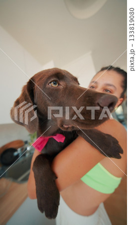 A Joyful and Playful Interaction Between a Happy Woman and Her Adorable Brown Dog 133819080