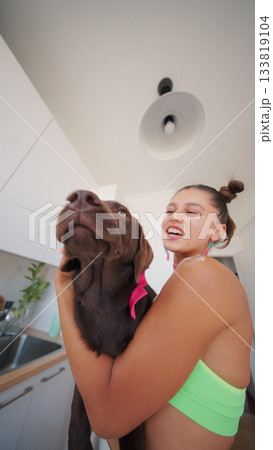A Joyful and Heartwarming Moment Spent with a Chocolate Labrador in a Bright Kitchen Area 133819104