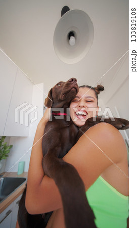 A Joyful and Happy Embrace with a Playful Chocolate Labrador in a Bright, Cheerful Kitchen 133819108