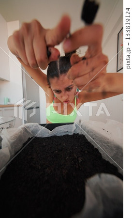 Planting seeds in soil is fulfilling for urban gardening enthusiasts passionate about food 133819124