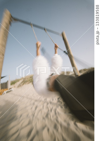 Experience the Joyful Swinging at the Beach with a Soft Focus to capture beautiful moments 133819588