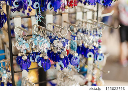 Craftsmanship shines at this market stall, featuring intricate blue keychains and charms, capturing the vibrant spirit of local artisans and shoppers enjoying the day 133822768