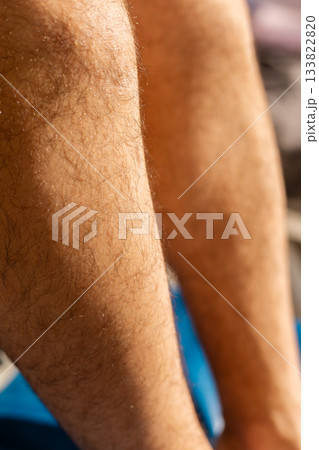 Close-up of male legs highlighting various hair textures and colors. Natural light enhances the details, showcasing a realistic view of hair growth patterns and skin Close-up of male legs highlighting various hair textures and colors. Natural light enhances the details, showcasing a realistic view of hair growth patterns and skin 133822820