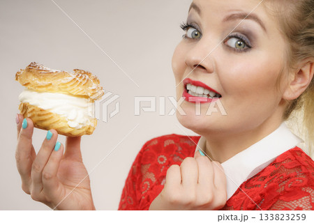 Funny woman holds cream puff cake 133823259