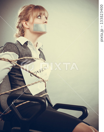 Woman bound by contract terms with taped mouth. 133823400