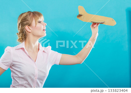 woman thinking about vacation holds airplane 133823404