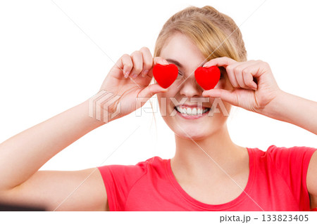 Funny woman holds red hearts over eyes Funny woman holds red hearts over eyes 133823405