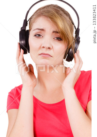 Woman sad girl in big headphones listening music 133823411