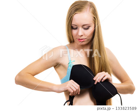 Woman trying on black bra 133823589