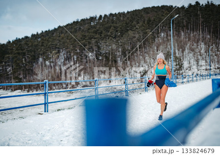 Elderly winter swimmer warming up before cold plunge in lake. Elderly winter swimmer warming up before cold plunge in lake. 133824679