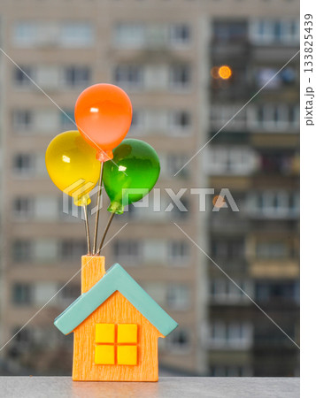 Miniature house with colorful balloons symbolizing dreams, hope, and the desire for your own home 133825439