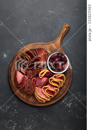 Charcuterie platter meat sliced salami pepperoni olives snack appetizer wooden board antipasto Charcuterie platter meat sliced salami pepperoni olives snack appetizer wooden board antipasto 133825563