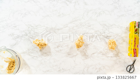 Dough divided onto cling wrap, ready to chill for Easter Cookie Sandwich with Raspberry Buttercream. Perfect for food preparation visuals and baking instruction content. 133825667