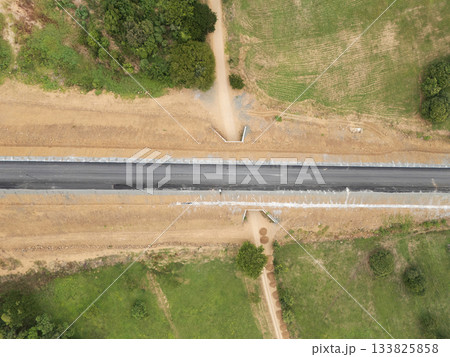 Newly constructed road connects rural areas with green fields 133825858