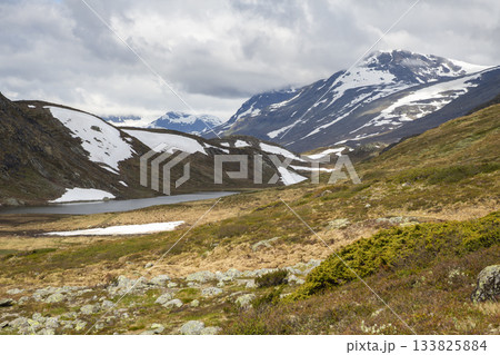 Hiking in Jotunheimen National Park near Bygdin hotel offers stunning views of Synshorn mountain and surrounding landscapes Hiking in Jotunheimen National Park near Bygdin hotel offers stunning views of Synshorn mountain and surrounding landscapes 133825884